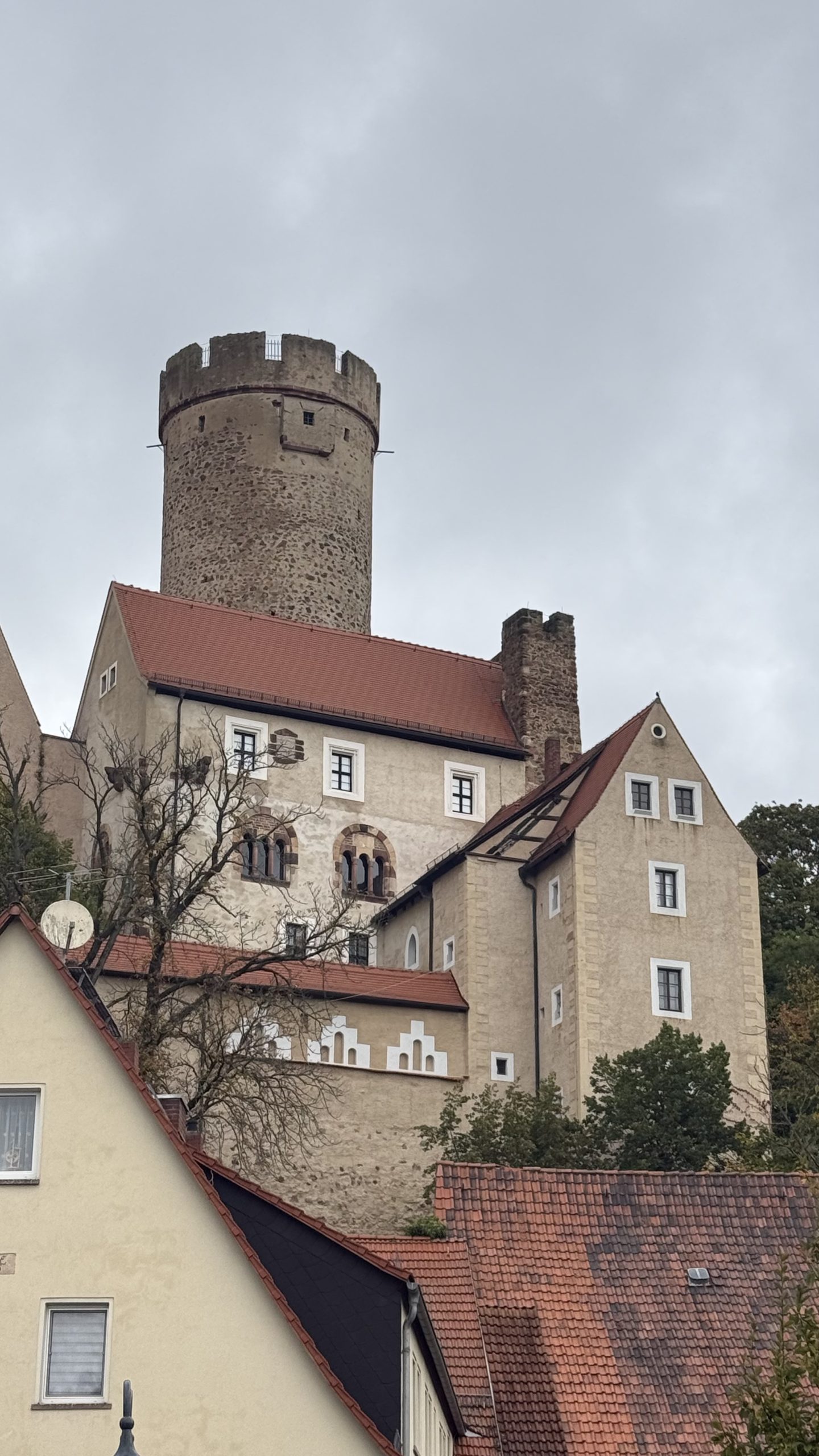 Burg Gnandstein mit Bergfried über den Dächern des Dorfes, Oktober 2026.